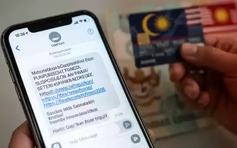Nahaufnahme eines Smartphone-Bildschirms mit betrügerischer SMS zu einer Rückerstattungsmasche, im Hintergrund eine unscharfe Hand mit Kreditkarte. - Foto: über boerse-global.de
