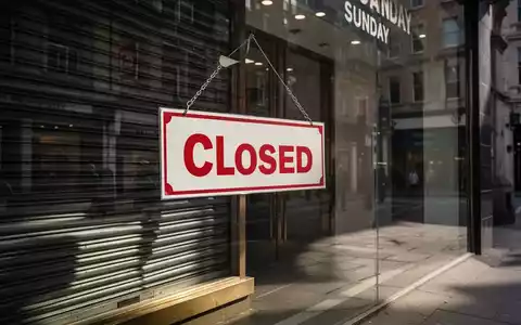 Ein geschlossenes Ladengeschäft an einem Sonntag mit einem deutlich sichtbaren 'Geschlossen'-Schild, das leere Straßen widerspiegelt. - Foto: über boerse-global.de