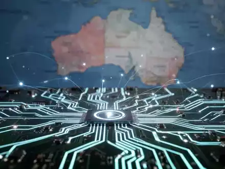 Nahaufnahme einer digitalen Platine mit leuchtenden Linien, die einen Netzwerkausfall darstellt, mit unscharfer Australienkarte im Hintergrund. - Foto: über boerse-global.de