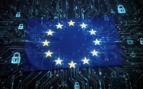 Eine leuchtende blaue EU-Flagge, die auf ein dunkles, abstraktes digitales Schaltplattendesign projiziert wird, mit Datenströmen und digitalen Schlosssymbolen. - Foto: über boerse-global.de