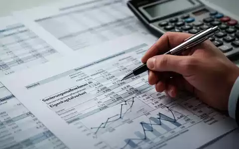 Eine Hand, die einen Stift hält, zeigt auf eine Finanzaufstellung mit Zahlen und Diagrammen, die sich auf Sanierungsmaßnahmen beziehen. - Foto: über boerse-global.de