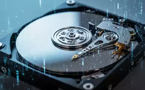 Nahaufnahme einer teilweise zerlegten Computerfestplatte mit sichtbaren Innenkomponenten unter kühlem Licht. - Foto: über boerse-global.de