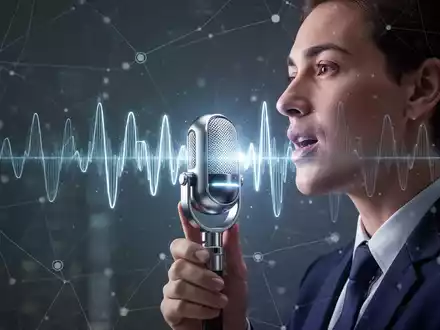 Eine Person spricht in ein futuristisches Mikrofon, mit einer leuchtenden Wellenform, die KI-Sprachtechnologie und globale Kommunikation darstellt. - Foto: über boerse-global.de