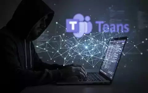 Person in Kapuzenjacke tippt auf Laptop, mit leuchtendem Netzwerk-Overlay und unscharfem Microsoft Teams-Logo im Hintergrund, symbolisiert Cyber-Bedrohungen. - Foto: über boerse-global.de