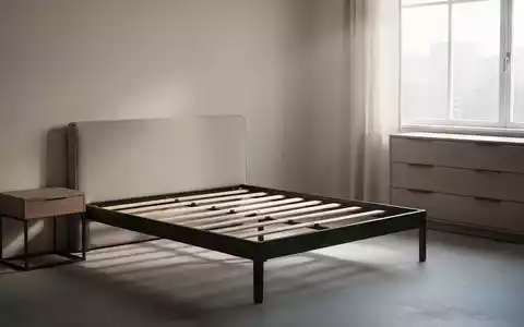 Ein minimalistisches Schlafzimmer mit einem leeren Bettrahmen, Nachttisch und Kommode in neutralen Farben, um eine Sortimentsumstellung anzudeuten. - Foto: über boerse-global.de