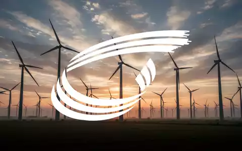 Windpark bei Sonnenaufgang mit zahlreichen Windturbinen, die sich gegen einen dramatischen, bewölkten Himmel abzeichnen. - Foto: über boerse-global.de