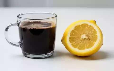 Ein Glas gefilterter schwarzer Kaffee neben einer aufgeschnittenen Zitrone auf einer weißen Oberfläche, die wissenschaftliche Klarheit symbolisiert. - Foto: über boerse-global.de