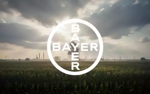 Abstrakte Darstellung des Agrarchemiesektors mit weichem Licht über einem Feld unter dramatischen Wolken, das eine große finanzielle Einigung symbolisiert. - Foto: über boerse-global.de