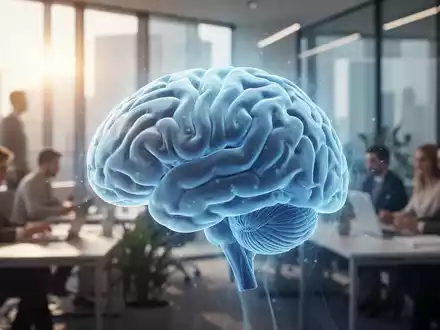 Ein stilisiertes, kühl leuchtendes Gehirn über einem unscharfen Bild eines modernen, sonnigen Büros mit arbeitenden Menschen. - Foto: über boerse-global.de