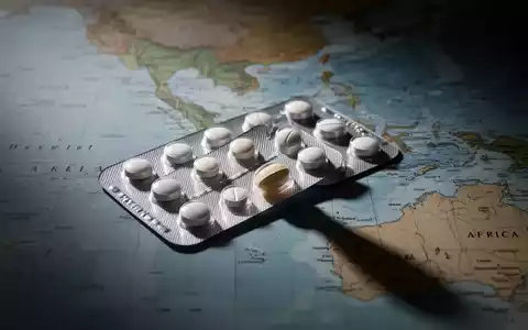 Ein Blisterpackung mit Pillen, eine Pille ist teilweise entfernt. Im Hintergrund eine verschwommene Weltkarte von Südostasien und Afrika. - Foto: über boerse-global.de