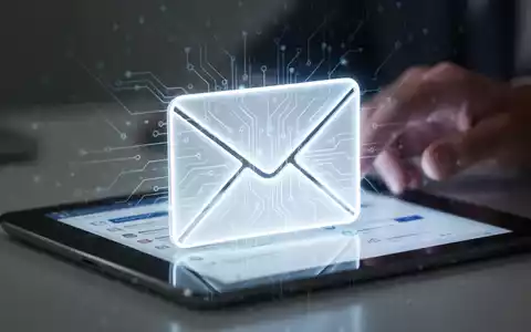 Leuchtendes, stilisiertes E-Mail-Symbol mit Leiterplattenmustern, das KI in der E-Mail-Verwaltung darstellt. Im Hintergrund eine unscharfe Hand mit Tablet. - Foto: über boerse-global.de
