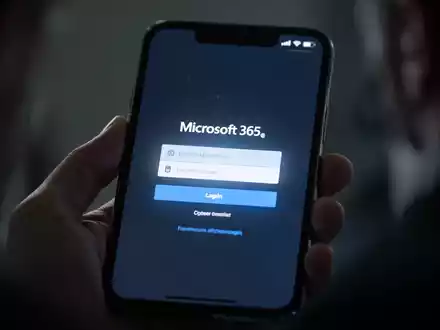 Nahaufnahme eines Smartphone-Bildschirms mit gefälschter Microsoft 365-Anmeldeseite, verschwommene Hand hält das Telefon. - Foto: über boerse-global.de