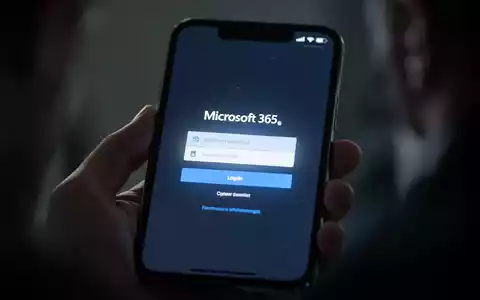 Nahaufnahme eines Smartphone-Bildschirms mit gefälschter Microsoft 365-Anmeldeseite, verschwommene Hand hält das Telefon. - Foto: über boerse-global.de