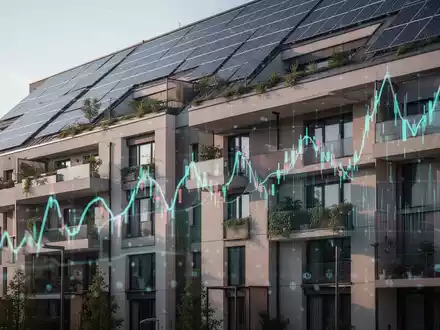 Eine moderne Gebäudefassade mit Solaranlagen und grünen Elementen, die finanzielle Anpassungen und Förderungen symbolisiert. - Foto: über boerse-global.de