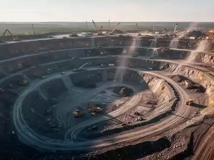 Luftaufnahme einer offenen Mine mit sichtbaren Erweiterungsgebieten und geologischen Merkmalen unter spätem Nachmittagslicht. - Foto: über boerse-global.de