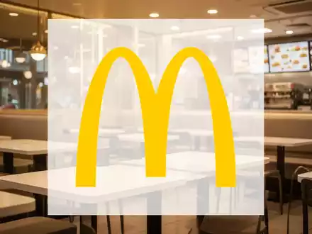 Ein goldener Schein beleuchtet ein modernes Fast-Food-Restaurantinterieur mit leeren Tischen. Die Stimmung ist ruhig und wohlhabend. - Foto: über boerse-global.de