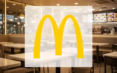 Ein goldener Schein beleuchtet ein modernes Fast-Food-Restaurantinterieur mit leeren Tischen. Die Stimmung ist ruhig und wohlhabend. - Foto: über boerse-global.de