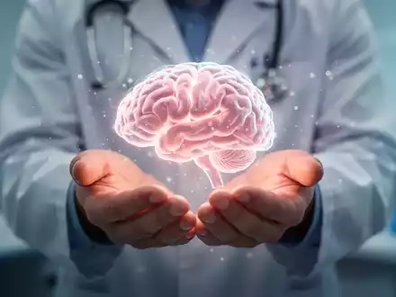Hände halten eine leuchtende, gehirnähnliche Struktur, umgeben von Lichtpartikeln, die Therapie und Forschung symbolisieren. - Foto: über boerse-global.de
