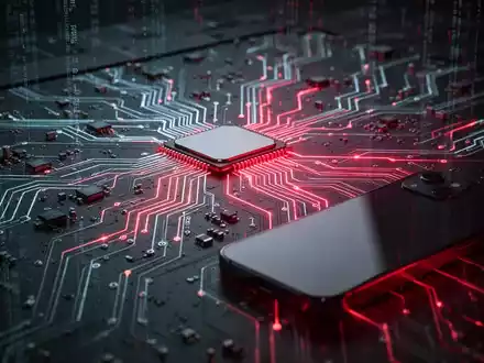 Nahaufnahme einer leuchtenden Leiterplatte mit rotem Licht, das einen Cyber-Angriff symbolisiert, und einem teilweise sichtbaren Smartphone. - Foto: über boerse-global.de