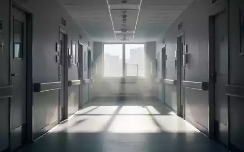 Ein heller, moderner Krankenhausflur mit Sonnenlicht am Ende, das lange Schatten wirft und Hitze andeutet. - Foto: über boerse-global.de