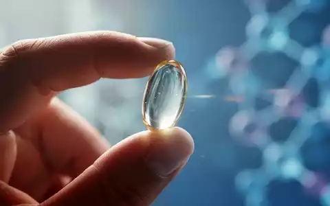 Eine Hand hält eine Omega-3-Kapsel vor einem unscharfen Hintergrund, der Wissenschaft und Forschung andeutet. - Foto: über boerse-global.de