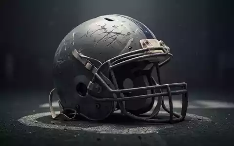Ein alter, zerkratzter American-Football-Helm liegt auf einer dunklen Oberfläche, im weichen Licht, das eine nachdenkliche Stimmung erzeugt. - Foto: über boerse-global.de