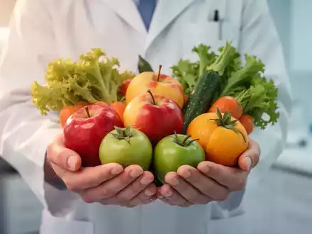 Hände halten eine Auswahl an frischem Obst und Gemüse, symbolisch für gesunde Ernährung und Pflege im Kontext der Krebstherapie. - Foto: über boerse-global.de