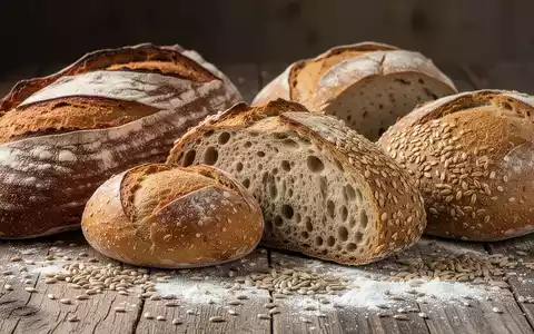 Nahaufnahme verschiedener gesunder Brotsorten, darunter Sauerteig- und Vollkornbrot, appetitlich auf einem Holztisch arrangiert. - Foto: über boerse-global.de