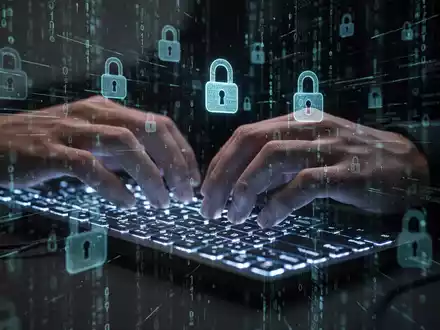 Nahaufnahme von Händen, die auf einer Tastatur tippen, mit überlagerten digitalen Sicherheitssymbolen, die Cyberbedrohungen und Datenverstöße darstellen. - Foto: über boerse-global.de