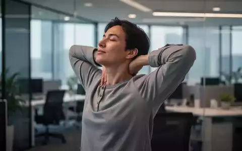 Eine Person dehnt im Büro vorsichtig Nacken und Schultern, um Verspannungen vorzubeugen. - Foto: über boerse-global.de