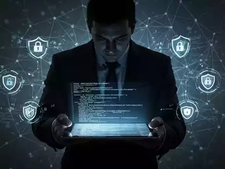 Eine dunkle Figur in einem Anzug hält ein leuchtendes Tablet mit Code, umgeben von Cybersicherheits-Symbolen und einem Netzwerkraster. - Foto: über boerse-global.de