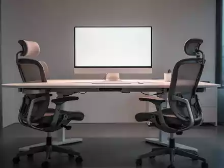 Ein moderner, ergonomischer Büroschreibtisch mit höhenverstellbarem Schreibtisch und ergonomischem Stuhl in einem hellen Büro. - Foto: über boerse-global.de