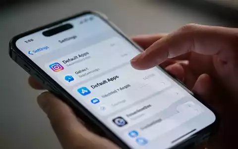 Nahaufnahme eines iPhone 16e-Bildschirms mit App-Einstellungen, eine Hand berührt die Oberfläche. - Foto: über boerse-global.de