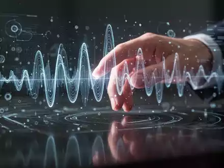 Eine Hand interagiert mit einem holografischen Audiowellen-Display, das Soundbearbeitung und digitale Medientechnologie symbolisiert. - Foto: über boerse-global.de
