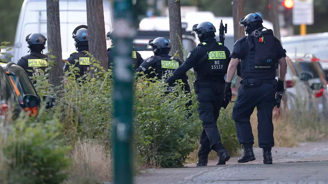  Polizisten sind in der Nähe von einem Supermarkt im Einsatz. - Bild: Carsten Koall/dpa