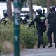  Polizisten sind in der Nähe von einem Supermarkt im Einsatz. - Bild: Carsten Koall/dpa