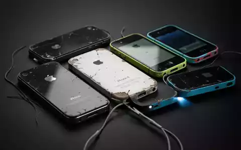 Nahaufnahme von Vintage iPhones (iPhone 4, 5, 5c) auf dunklem Hintergrund, dezent beleuchtet, symbolisiert ältere Technologie. - Foto: über boerse-global.de
