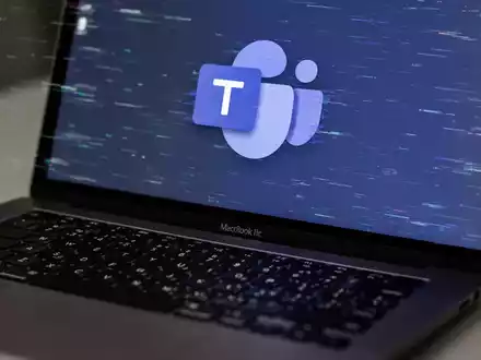 Nahaufnahme einer MacBook-Tastatur mit glitchigem Microsoft Teams-Logo auf dem Bildschirm, das Softwarefehler symbolisiert. - Foto: über boerse-global.de