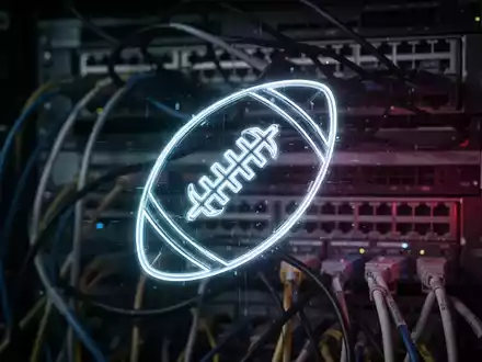 Leuchtendes digitales Fußball-Symbol vor verschwommenen Server-Racks, symbolisiert Cyberangriff auf Fußballverband. - Foto: über boerse-global.de
