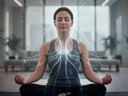 Eine Person meditiert ruhig, umgeben von sanften Lichtströmen, die neuronale Aktivität oder Energiefluss andeuten. - Foto: über boerse-global.de