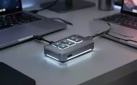 Schlankes, minimalistisches Drei-Tasten-Mini-Keypad per USB-C mit MacBook verbunden, sanft leuchtend auf modernem Schreibtisch. - Foto: über boerse-global.de