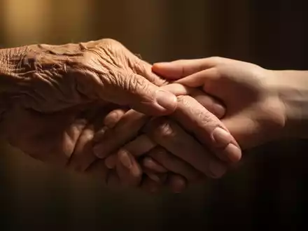 Eine ältere, faltige Hand berührt sanft eine jüngere, glatte Hand, symbolisierend den Alterungsprozess und Generationsunterschiede. - Foto: über boerse-global.de