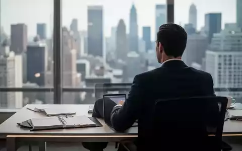Eine Person sitzt an einem aufgeräumten Schreibtisch in einem modernen Büro und blickt auf eine verschwommene Stadtlandschaft. - Foto: über boerse-global.de