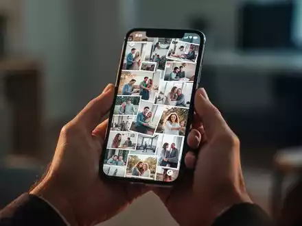 Eine Person hält ein Smartphone, dessen Bildschirm eine überfüllte Galerie digitaler Fotos zeigt, um die Menge digitaler Erinnerungen zu symbolisieren. - Foto: über boerse-global.de
