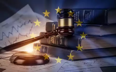 Ein stilisierter Hammer liegt auf einem Stapel von Gesetzbüchern mit einer subtilen Überlagerung eines EU-Flaggensymbols. - Foto: über boerse-global.de
