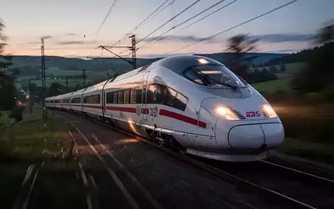 Ein moderner Hochgeschwindigkeitszug fährt bei Dämmerung durch eine verschwommene Landschaft, symbolisch für Pünktlichkeitsprobleme der Bahn. - Foto: über boerse-global.de