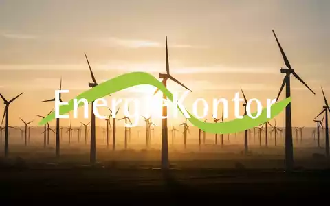 Windpark bei Sonnenaufgang mit riesigen Windturbinen, die sich gegen einen goldenen Himmel abzeichnen. - Foto: über boerse-global.de