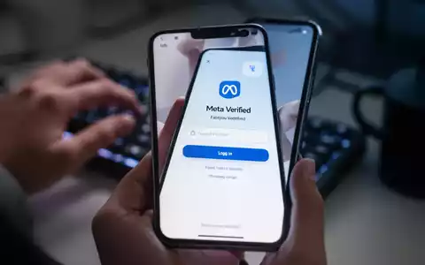 Ein Smartphone zeigt eine gefälschte Meta-Verified-Anmeldeseite, im Hintergrund unscharfe Hände auf einer Tastatur. - Foto: über boerse-global.de