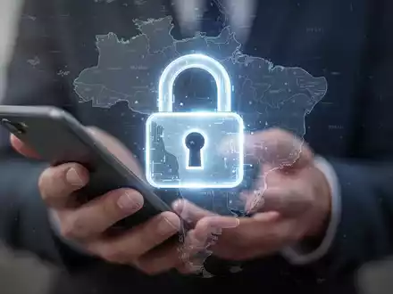 Leuchtendes digitales Vorhängeschloss über unscharfer Hand mit Smartphone und Brasilienkarte, symbolisiert sichere mobile Kontowiederherstellung. - Foto: über boerse-global.de