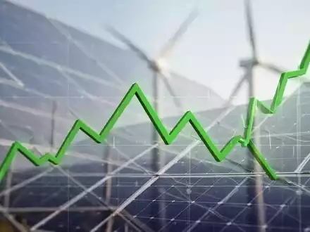 Ein fallender grüner Börsenchart vor einem unscharfen Hintergrund von Solarpaneelen oder Windturbinen, der den Rückgang von Clean Energy Aktien symbolisiert. - Foto: über boerse-global.de